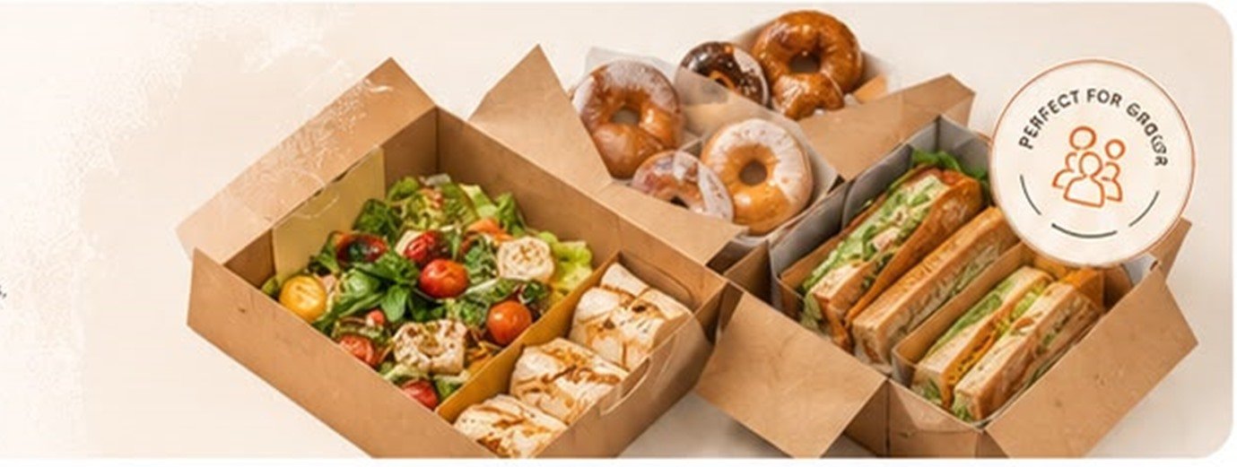 Catering boxes filled with salads, wraps, sandwiches and bagels